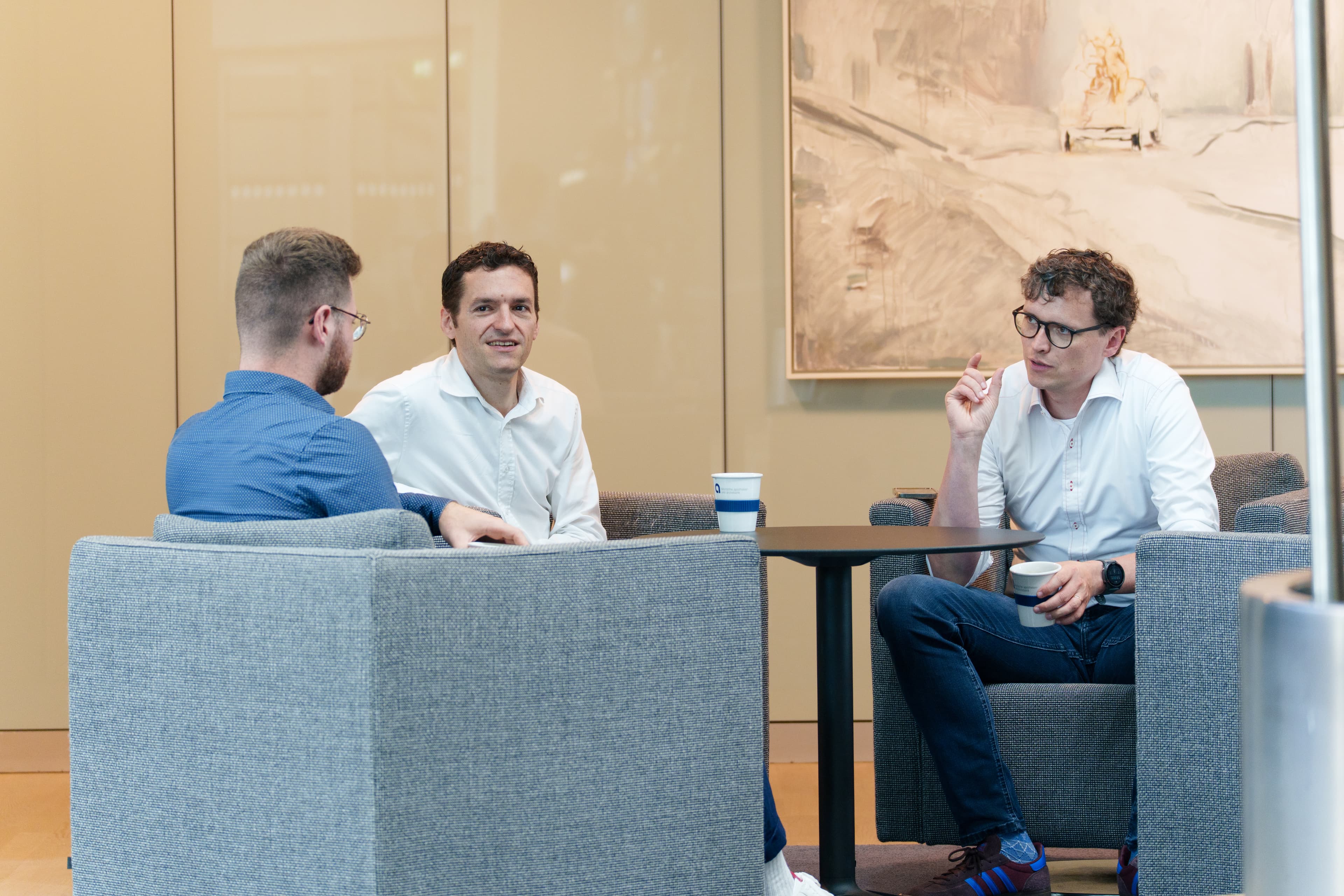 Drei Mitarbeitende am Tisch in der Pause