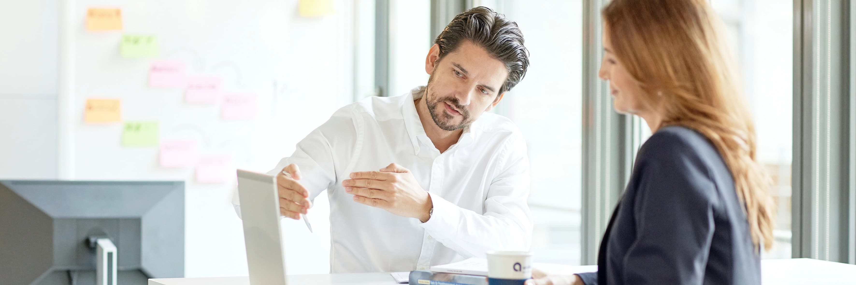 Zwei Mitarbeiter stehen vor dem PC